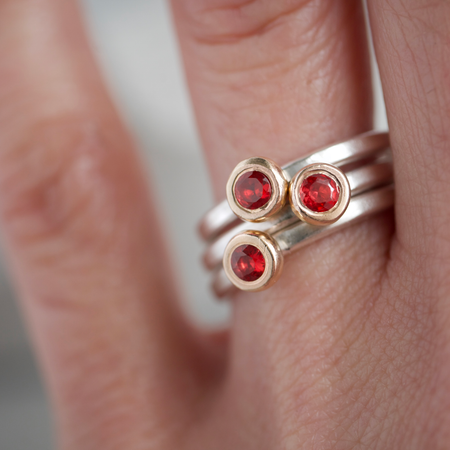 Mixed metal red sapphire stacking rings worn by Natalie Vernazza elegant jewellery.