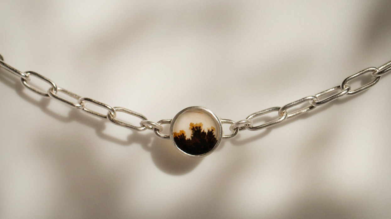 A dendritic agate set in a silver paperclip chain bracelet